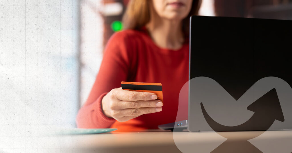 A person using a laptop with their credit card ready to make a purchase